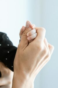 Close-up of a mother and baby's hands, symbolizing love and bond.